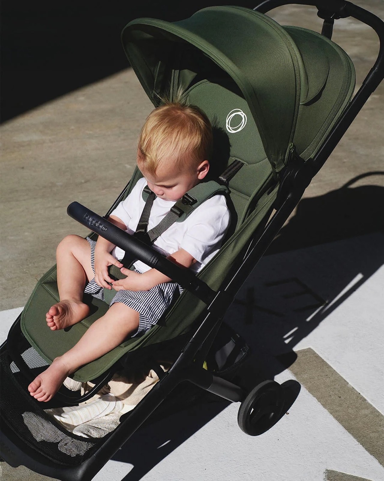 A baby playing while sitting in the Bugaboo Butterfly 2 travel pram