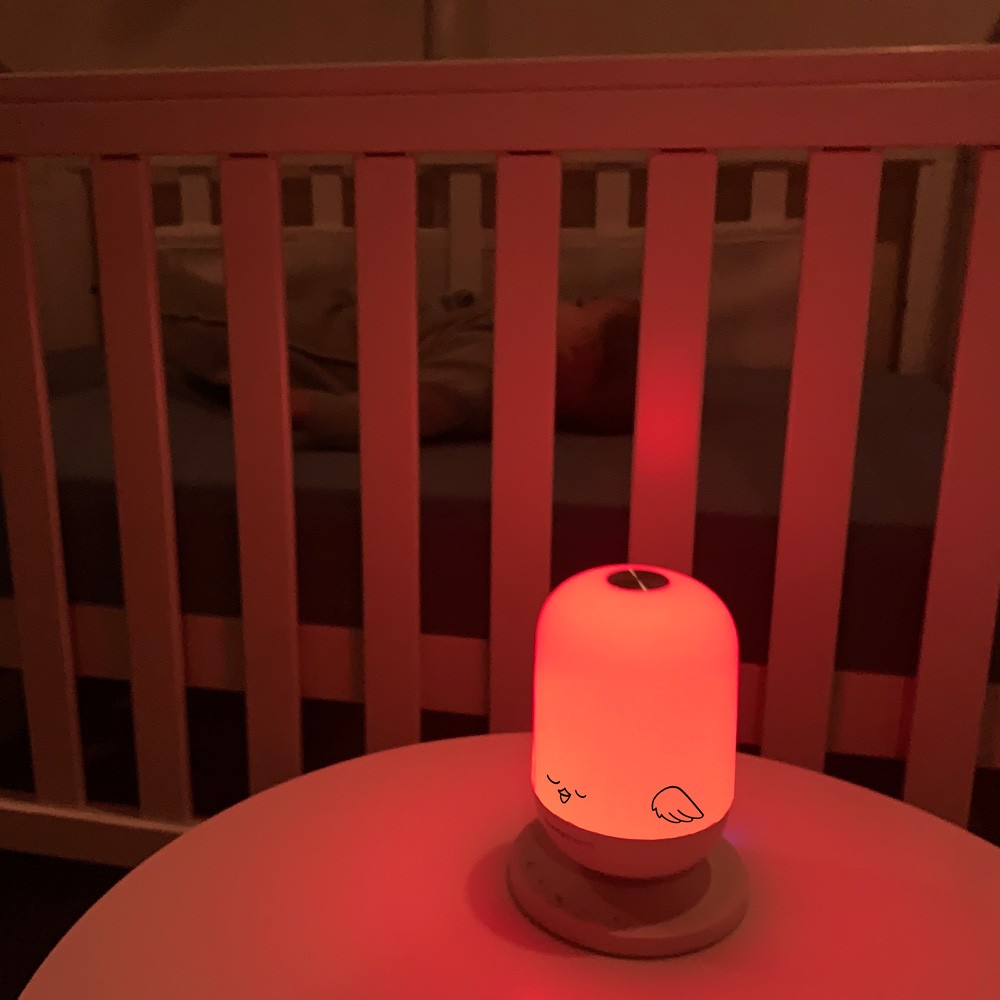 TweetyDreams best white noise machine on a table featuring a red glow, perfect for nighttime use