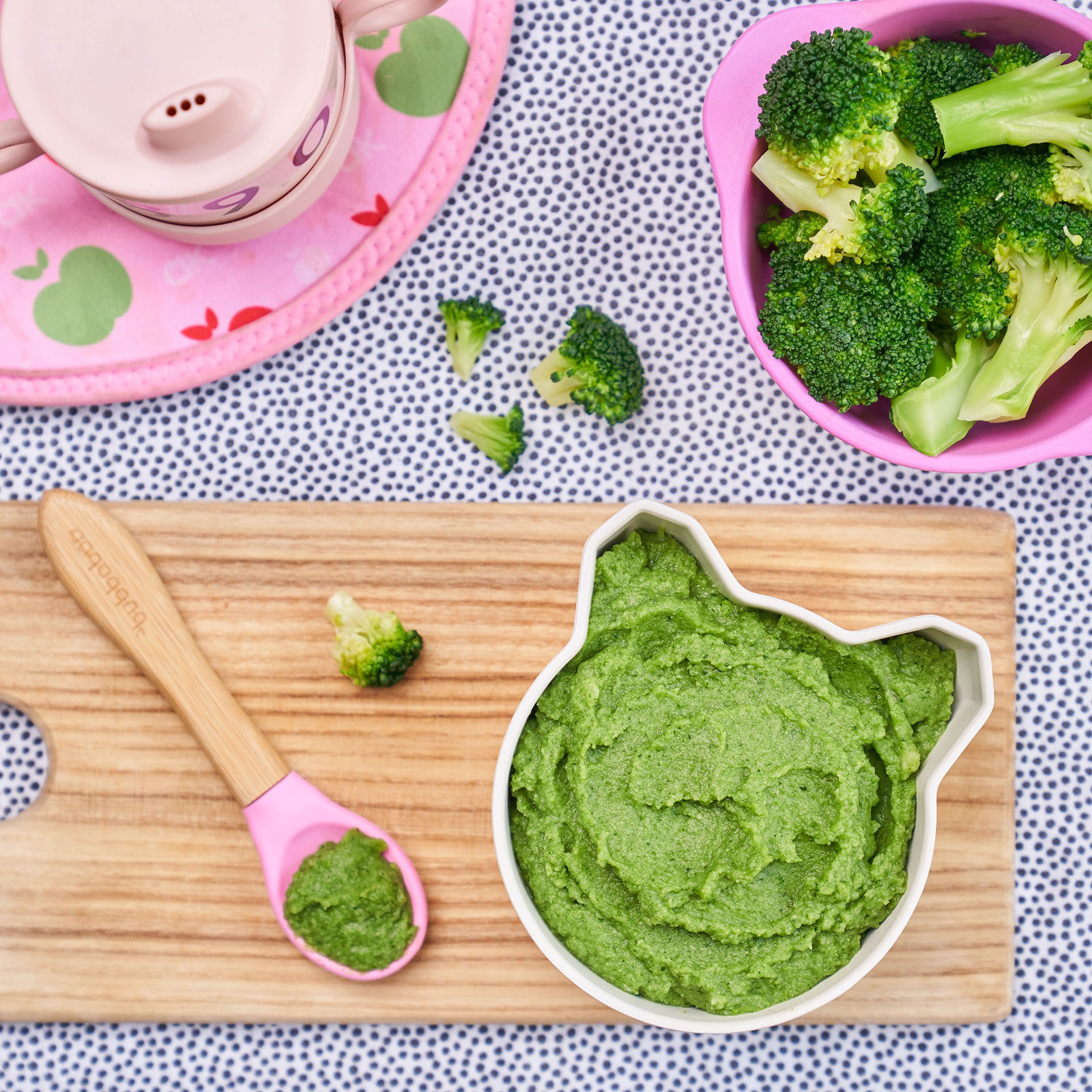 Broccoli puree served in a pink silicone cat plate, a nutritious option for baby led weaning first foods.
