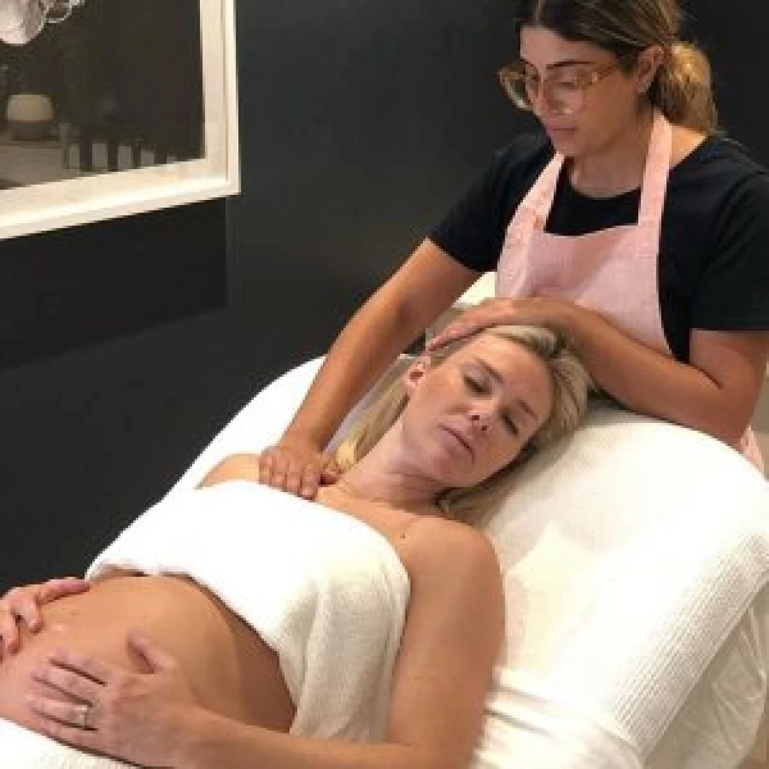 Close-up of a pregnant mum lying on the massage bed enjoying the Best Pregnancy Massage.