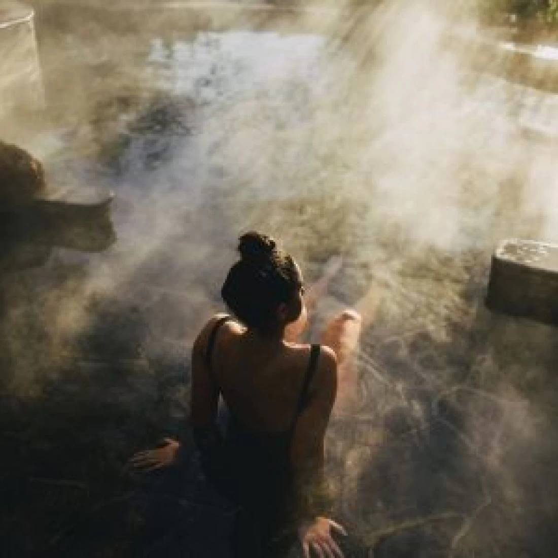 Pregnant woman relaxing in a hot spring as part of the Best Pregnancy Massage spa retreat.