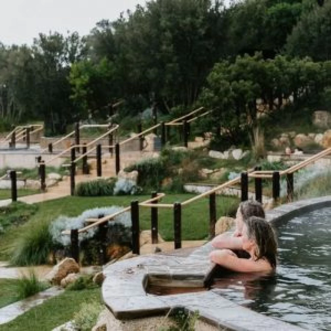 Women soaking in a calming hot spring at a spa offering the Best Pregnancy Massage
