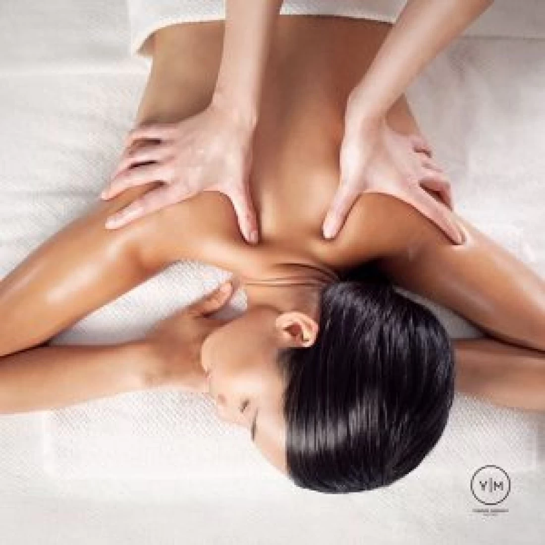 Close-up of therapist’s hand massaging the back in a spa offering the Best Pregnancy Massage.