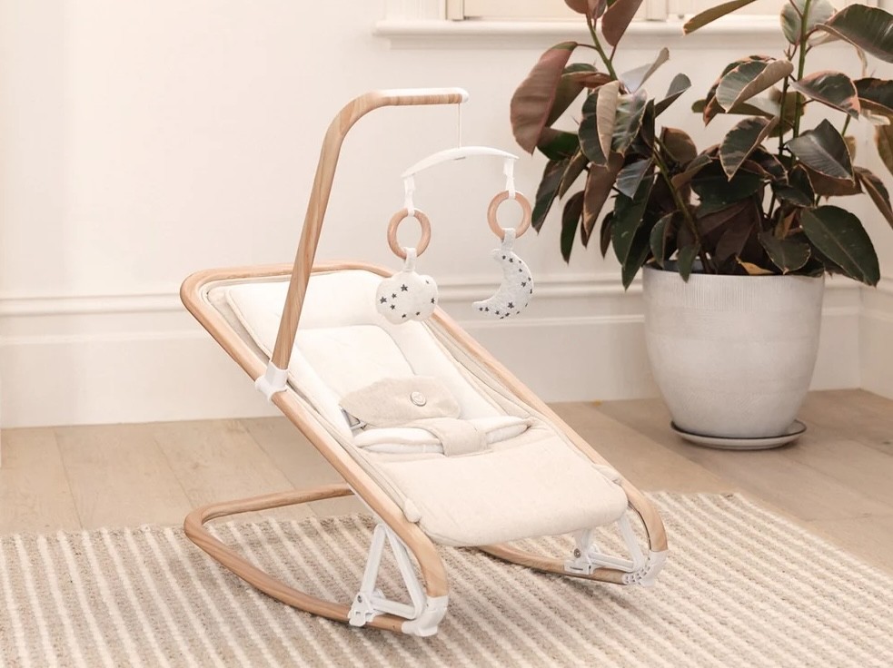 The babybee lola rocker shown in a minimalist room with a pot plant behind it