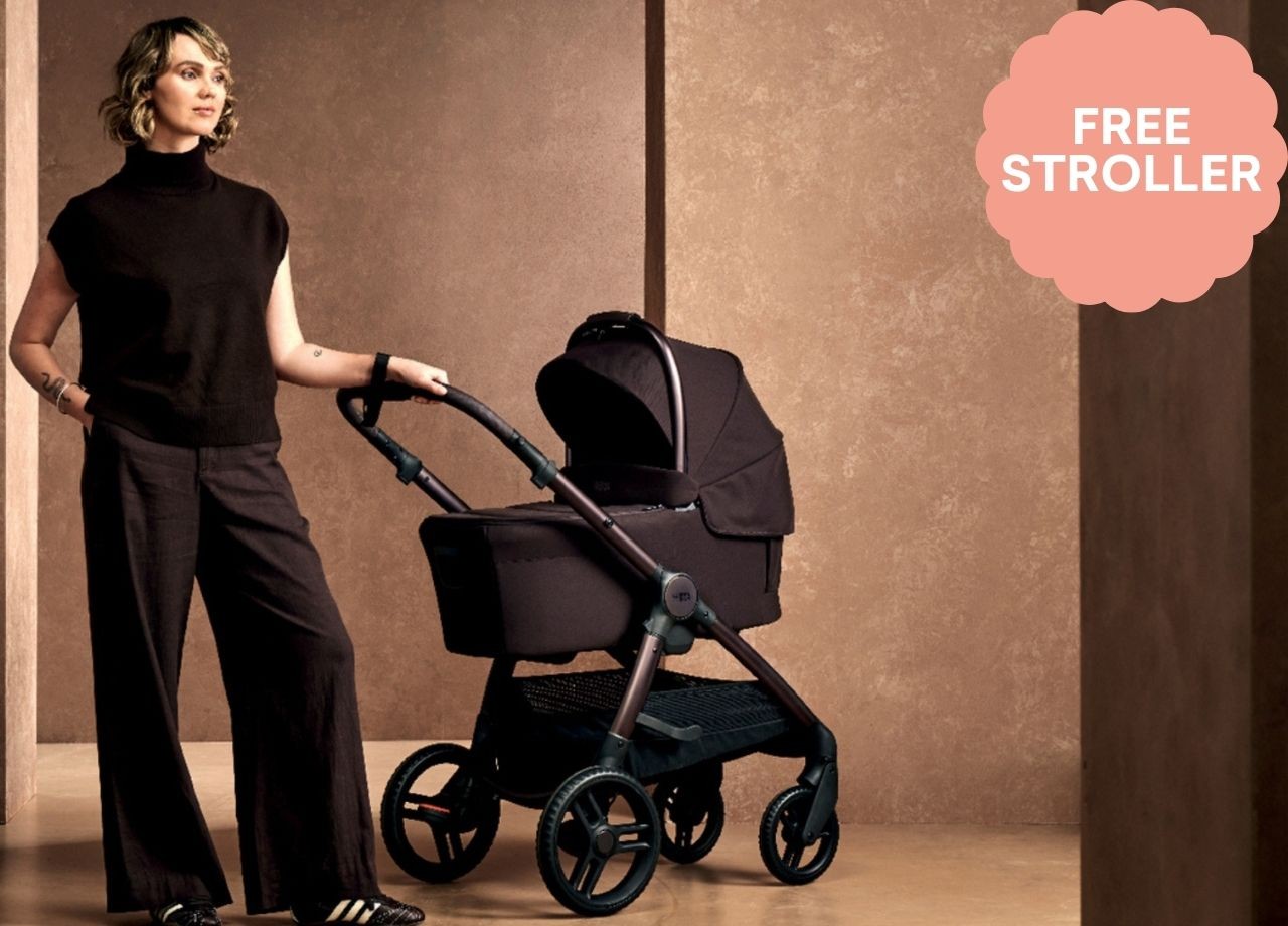 A woman standing next to a black pram