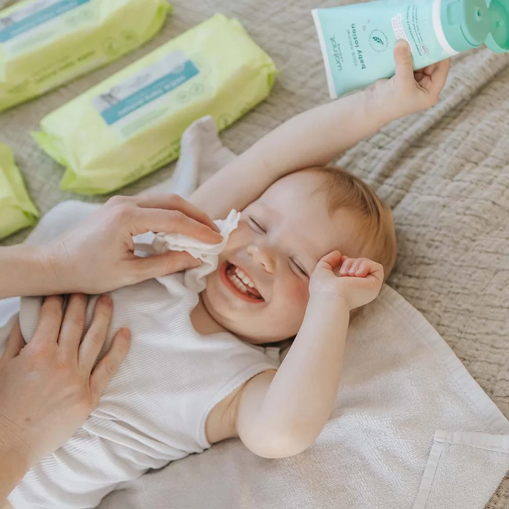 a baby laughing as an australian mum wipes their face with wotnot baby wipes