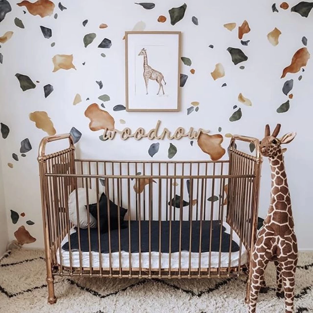 Nursery styled with giraffe plush toy and minimalist animal wall art, showcasing the best baby boy nursery room decor ideas.