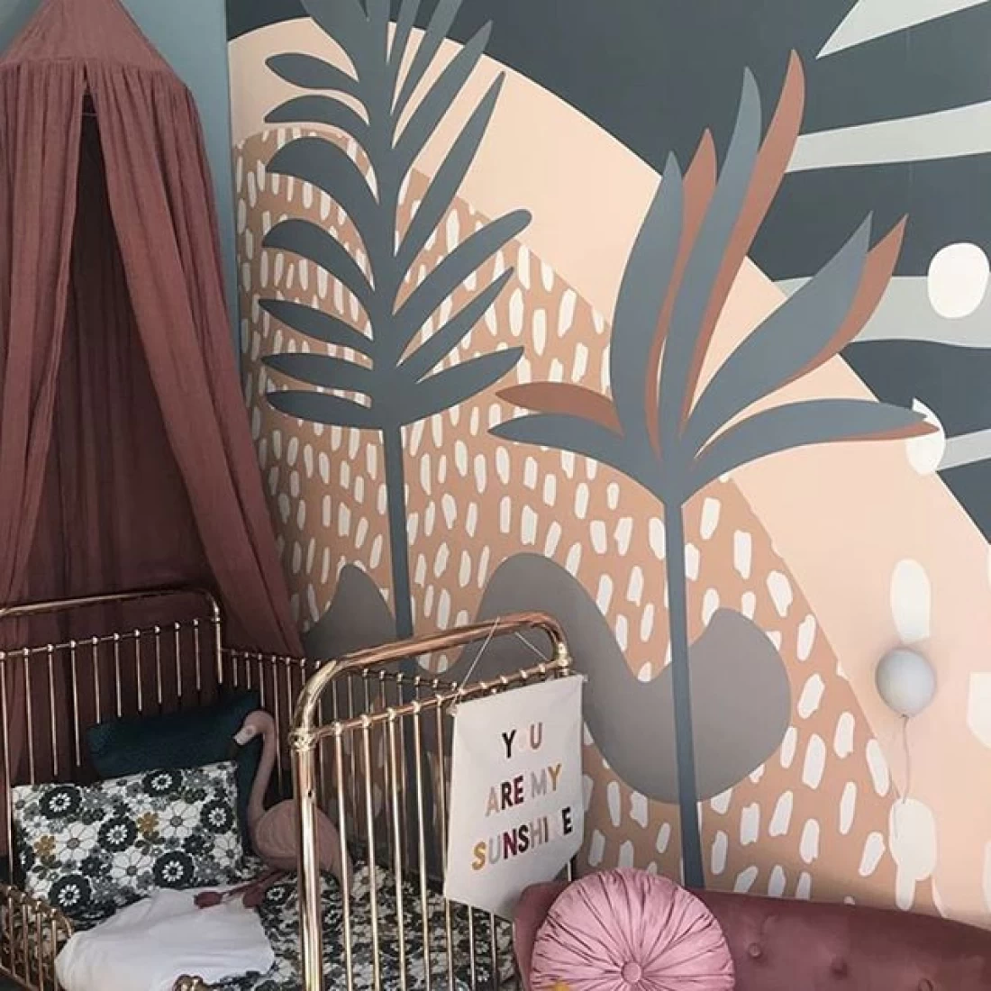 Modern nursery with plant wall art above a white crib, showcasing the best baby boy nursery room decor ideas.