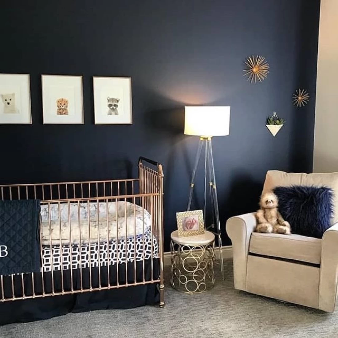 Modern nursery design with black wall, white chair, and gold crib, showcasing the best baby boy nursery room decor ideas.