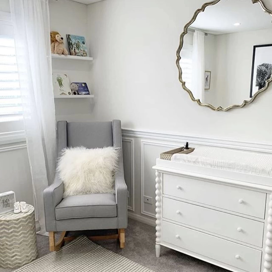 Neutral grey chair with white drawer styled in a nursery, showcasing the best baby boy nursery room decor ideas.