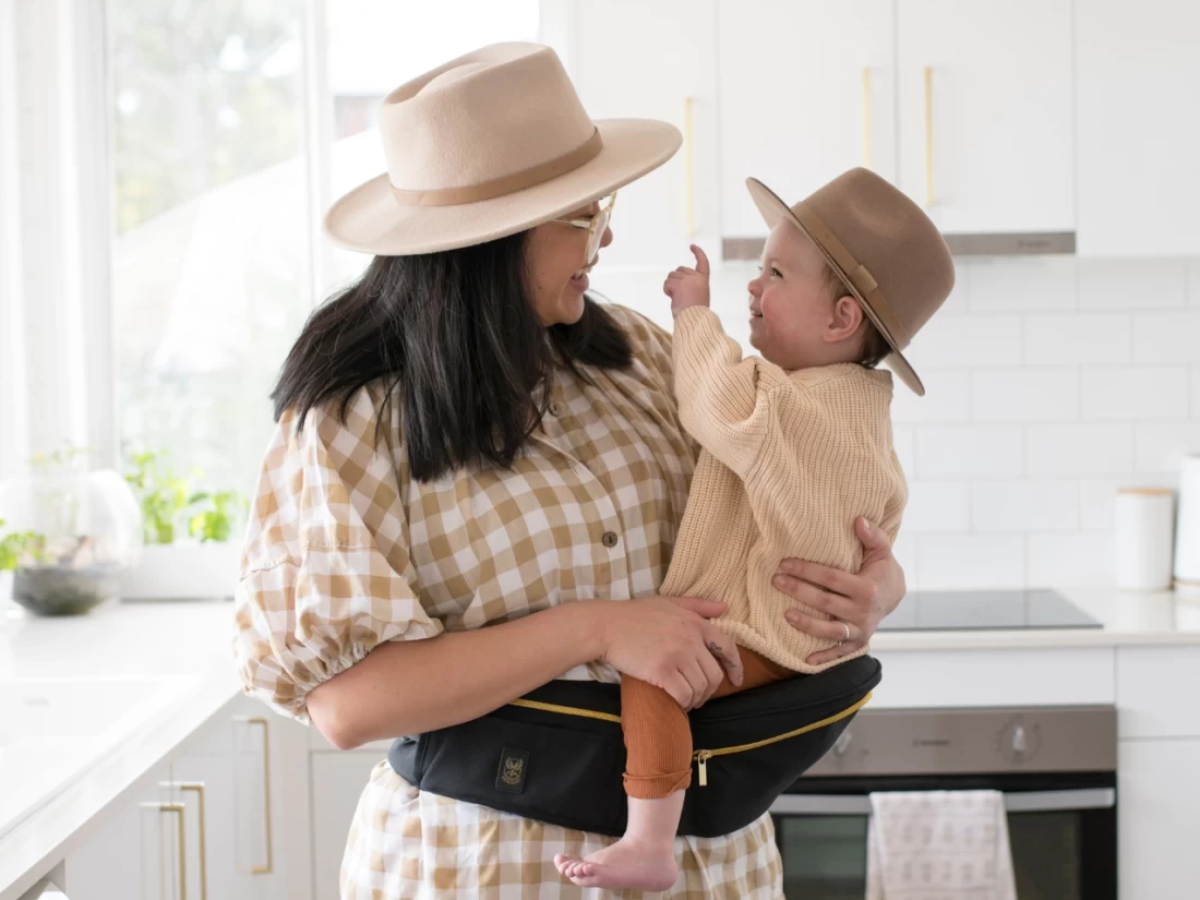 Happy mother bonding with her baby while wearing Hackerlily HipSurfer, the best baby carrier with hipseat